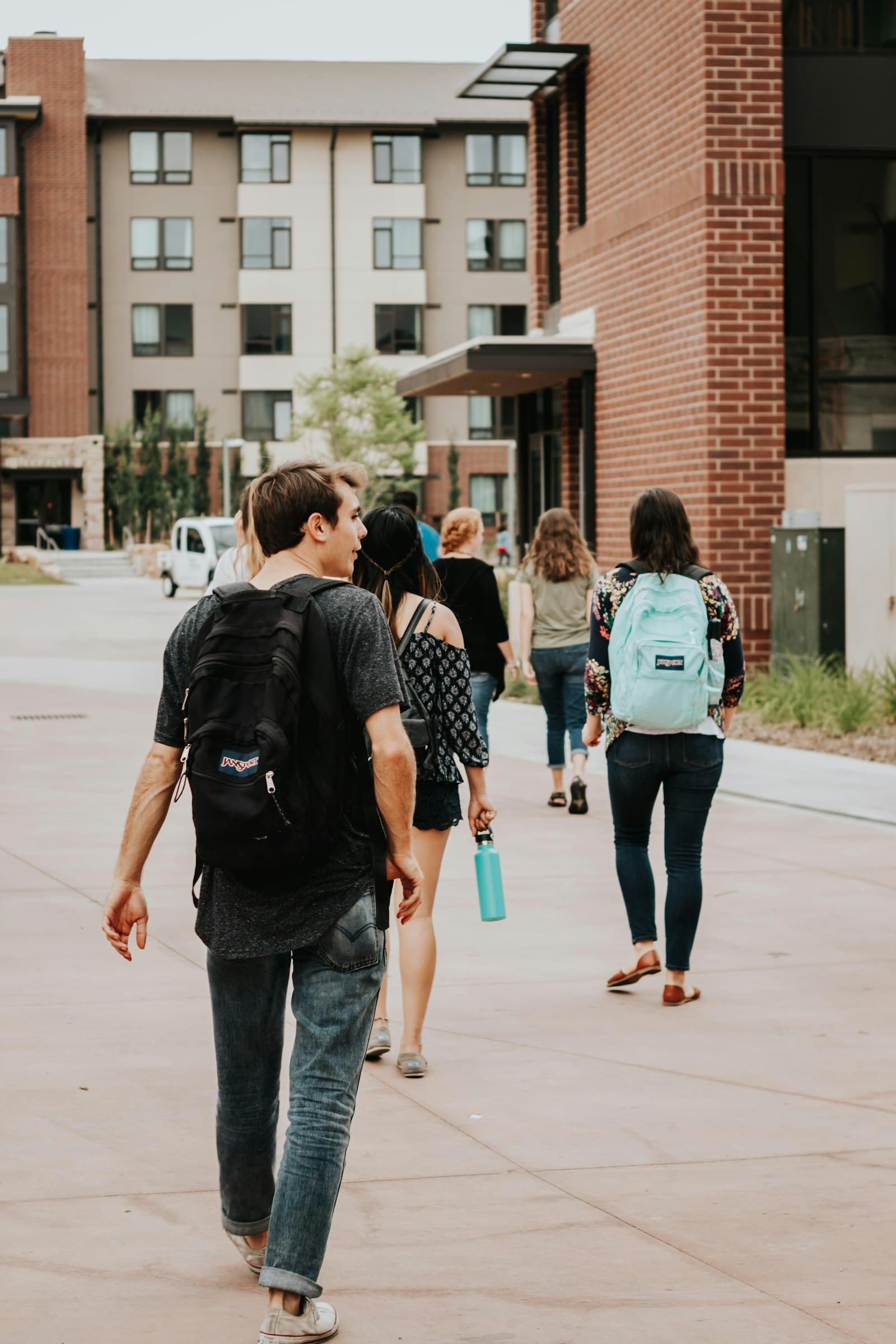 Student walking across a university campus with a backpack